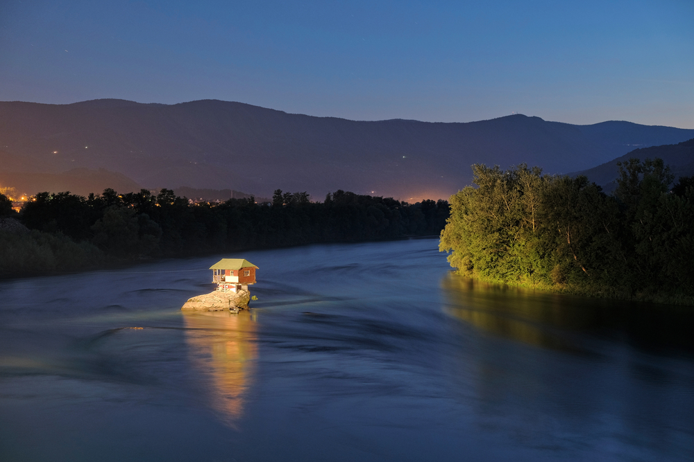 wooden house on a rock of Drina River by night, Serbia