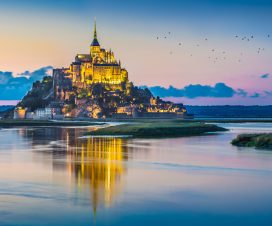 Panoramic view of famous Le Mont Saint-Michel tidal island in beautiful twilight during blue hour at dusk, Normandy, northern France
