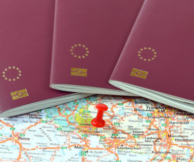 Schengen on the map marked with a red a pin and EU passports