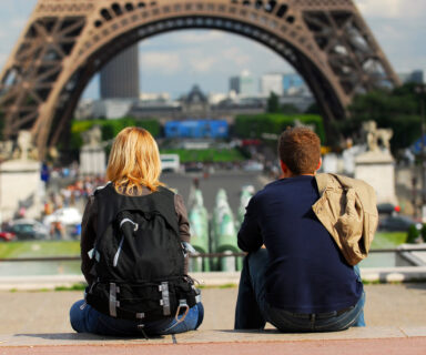 Young tourist couple sitting in front of Eiffel tower in Paris France