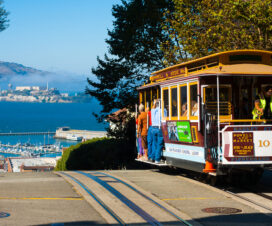 Powell Hyde cable car, an iconic tourist attraction, descends a steep hill overlooking Alcatraz prison and SF bay on September 21, 2011 in San Francisco, USA